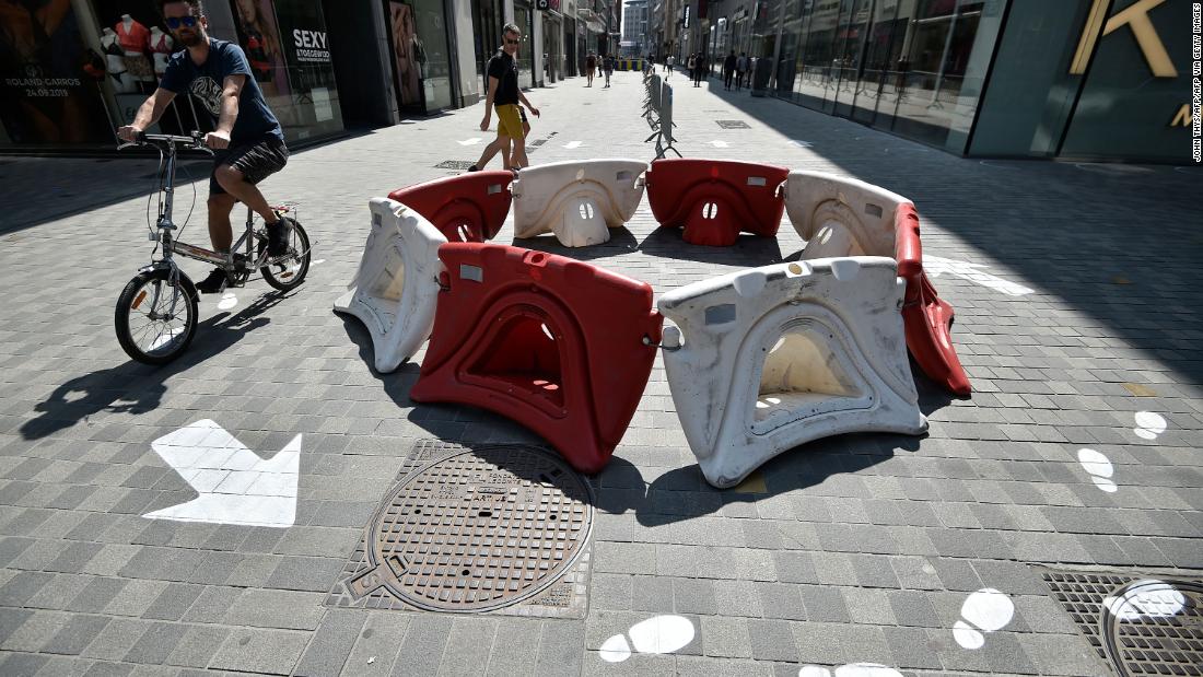 A man rides past social-distancing markers in front of a shop in Brussels, Belgium, on May 9.